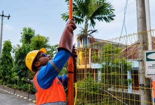 Petugas PLN UID Yogyakarta memantau pemasangan umbul-umbul di dekat jaringan listrik